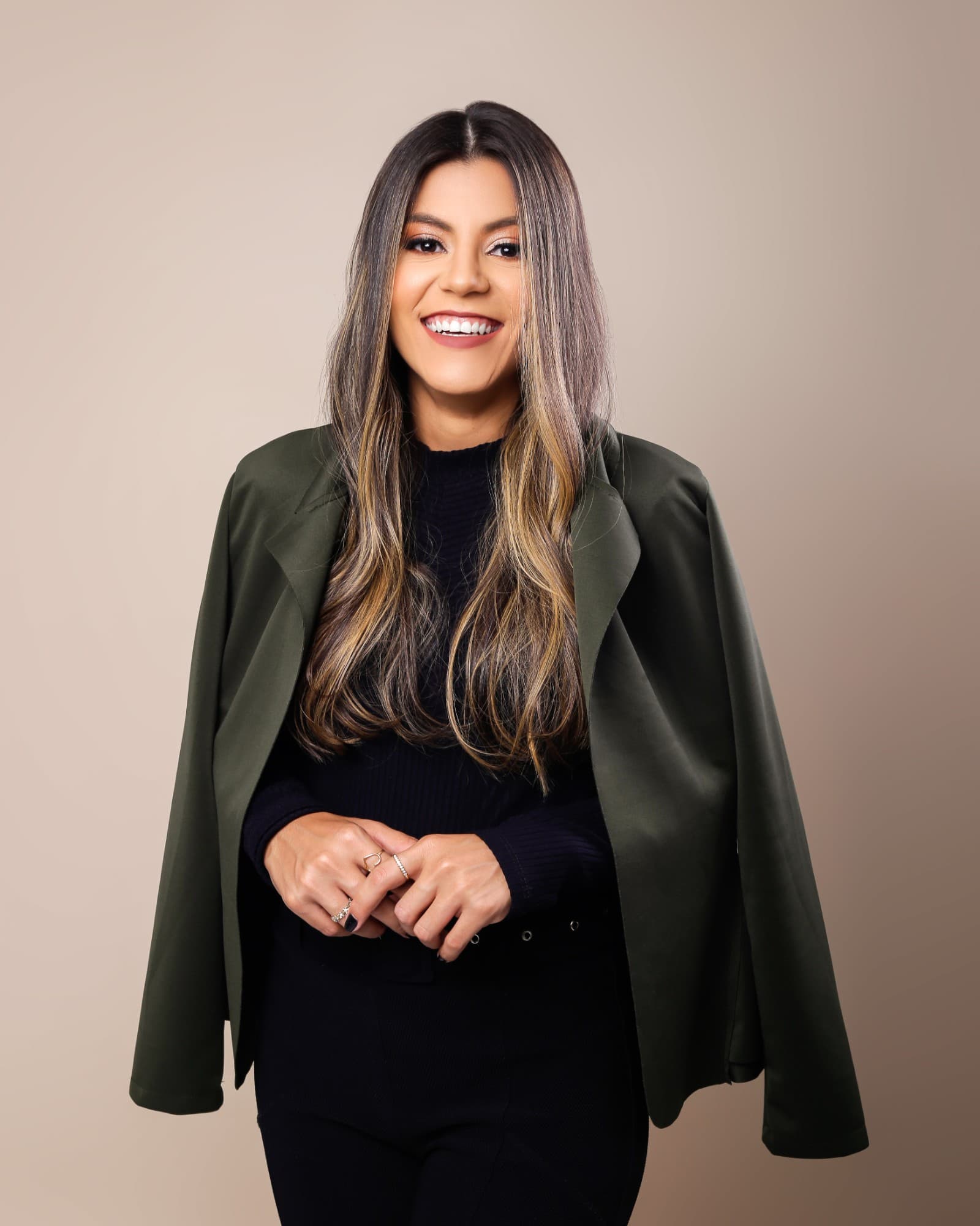 Ially Gomes sorrindo, com blazer verde-oliva